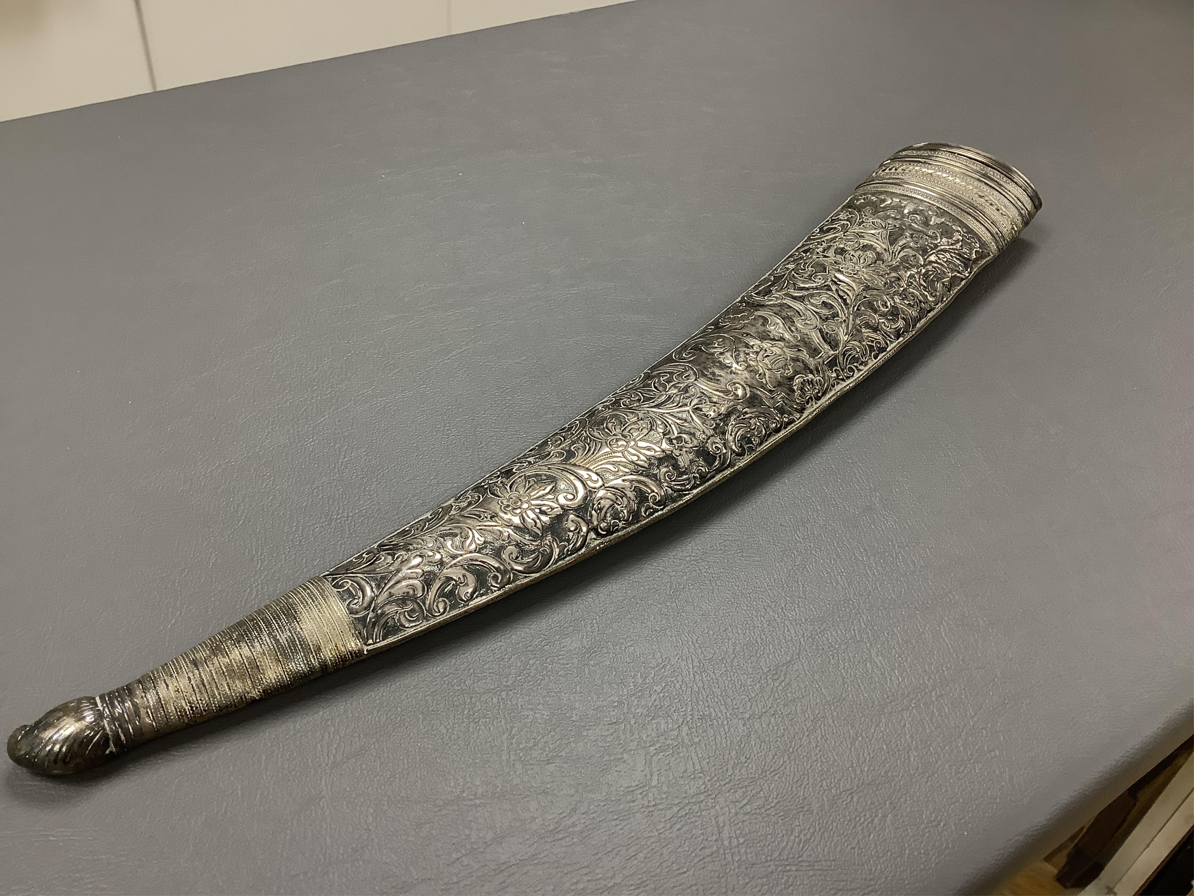 Eighteen assorted world weapons comprising a silver jambya (pommel missing), a knobkerry, a dha, two kris (one with handle missing), a lohar, three kukris, a djambok, a Chinese trousse, a chora, a flyssa, five others and